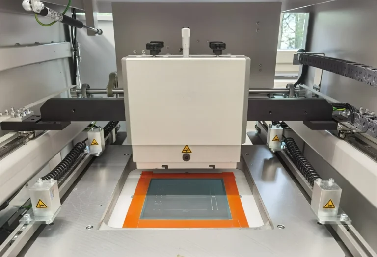 This is a grey screen printer. It is open, allowing you to see the green screen and the squeegee holder.