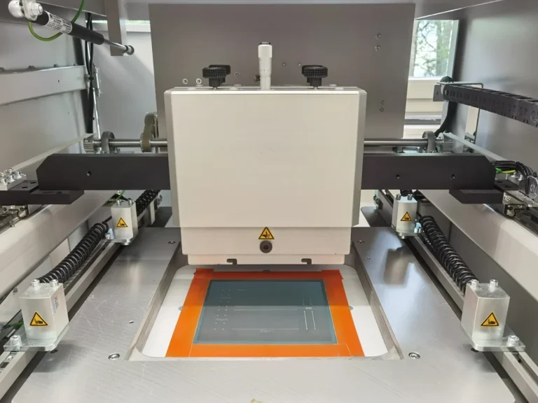 Screen Printer This is a grey screen printer. It is open, allowing you to see the green screen and the squeegee holder.