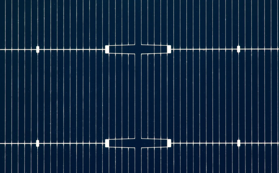 Close-up of the front of a solar cell with fingers and busbars made of silver.